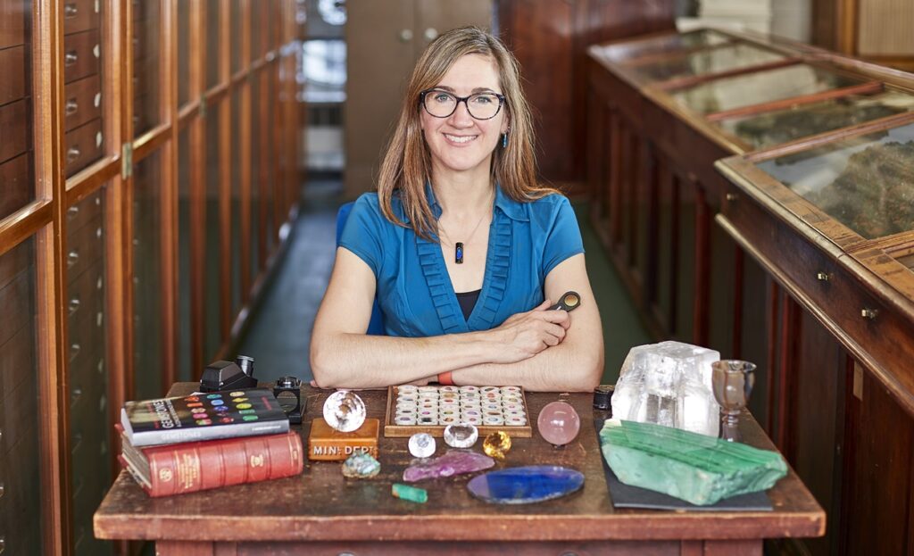 woman smiling in front of collection of gems